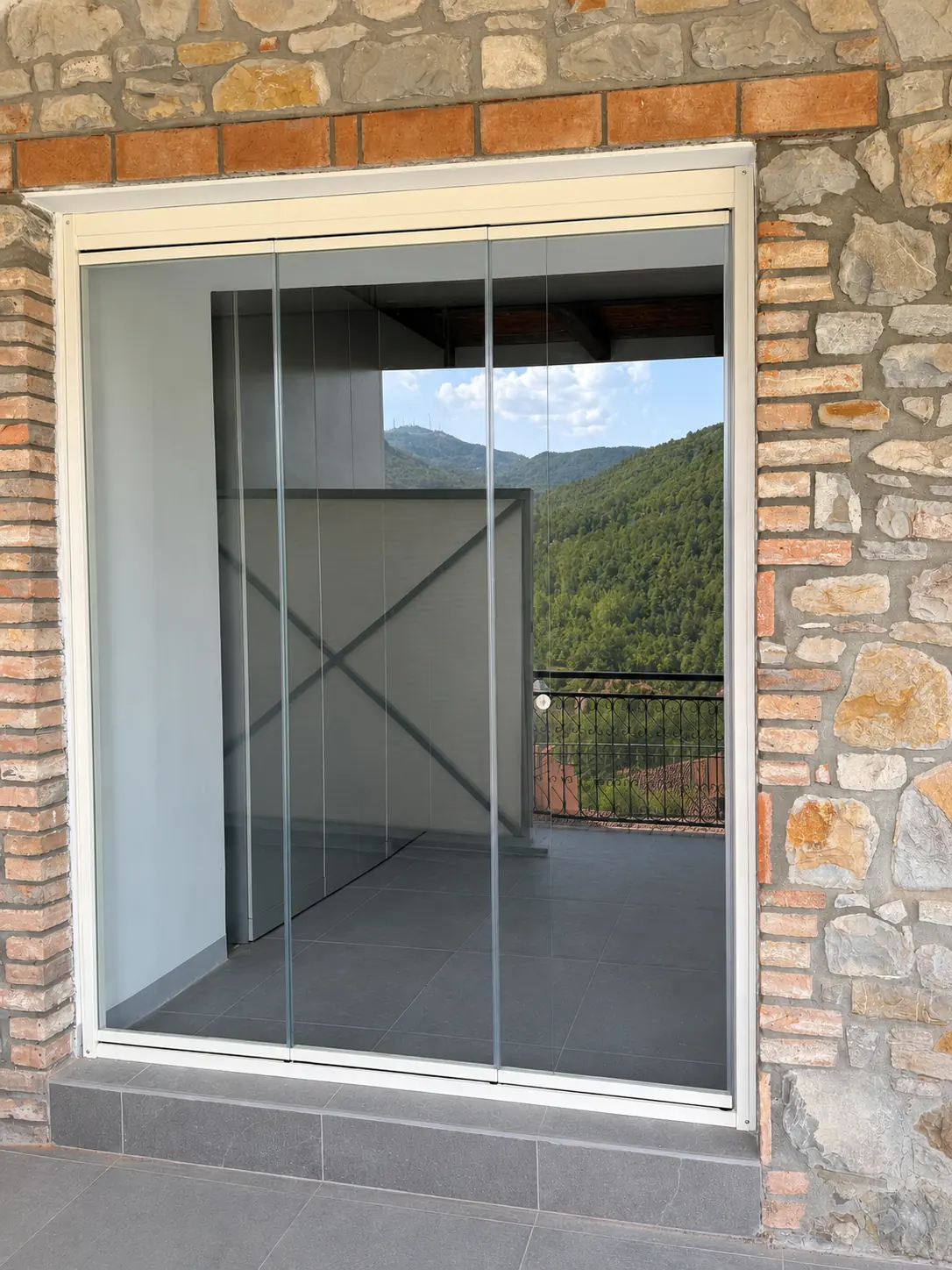 Sistema vetrato chiuso inserito in una parete in pietra e mattoni
